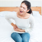 Woman holding side of her stomach in pain