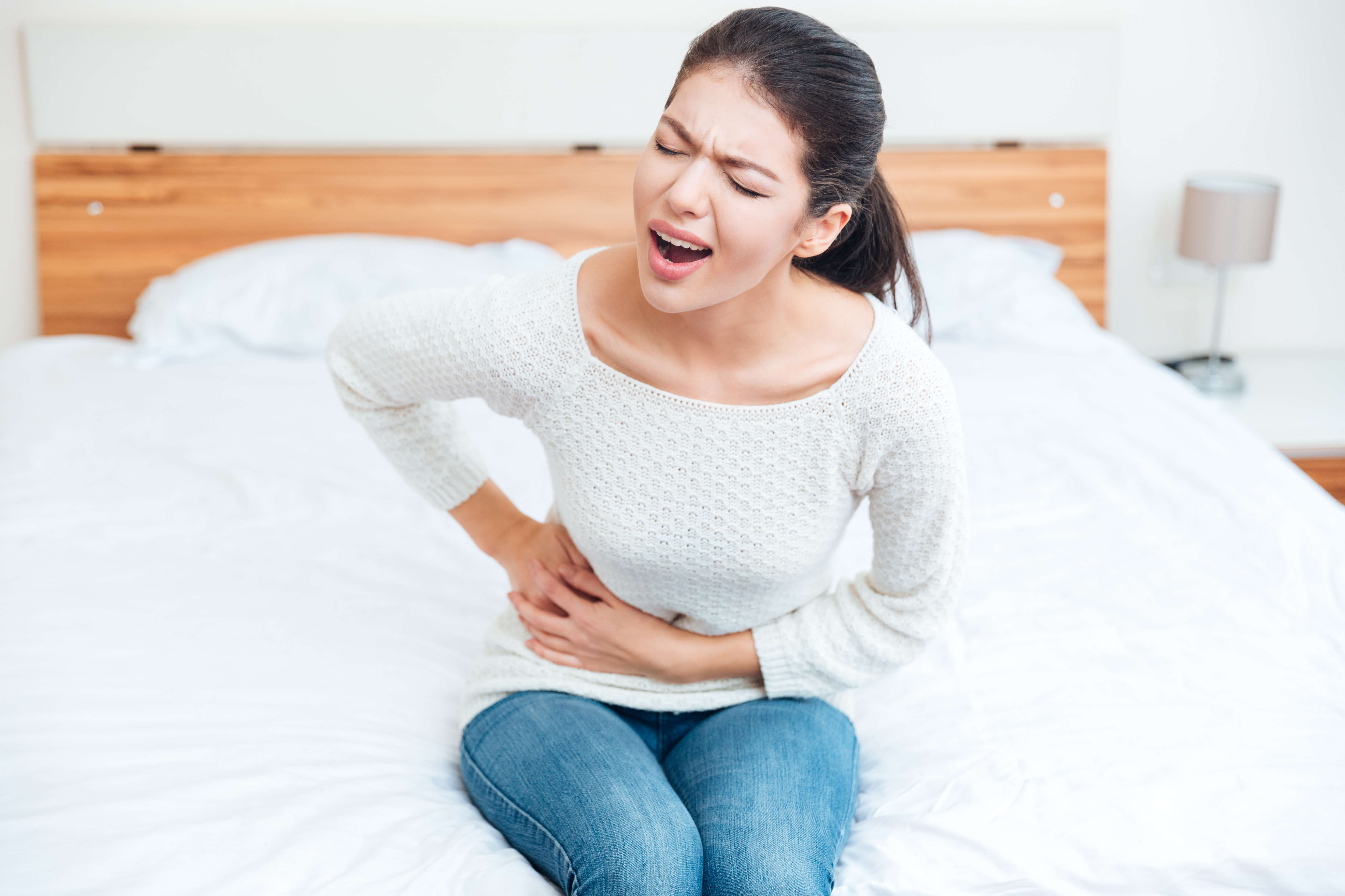 Woman holding side of her stomach in pain